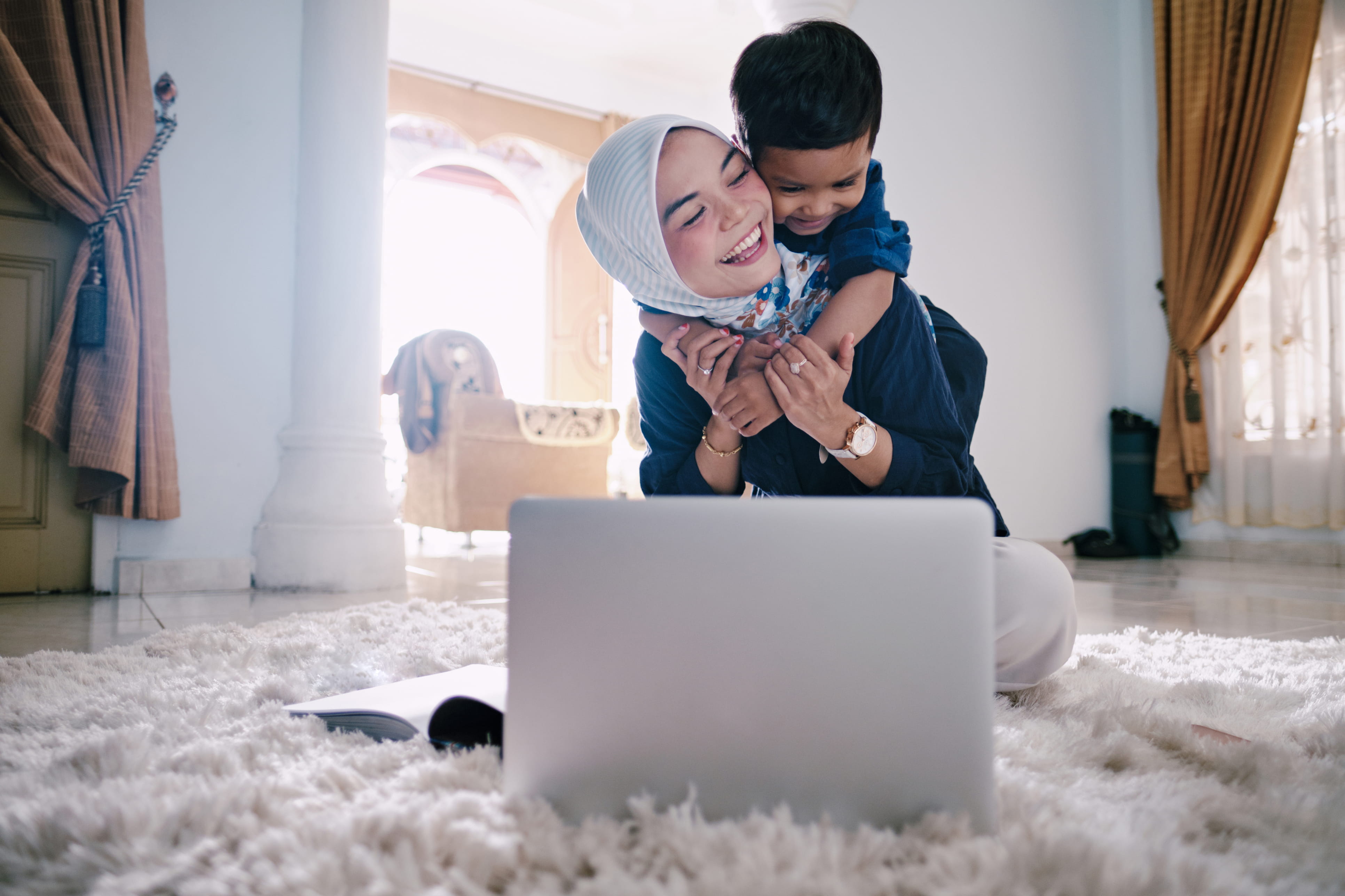 mother and boy checking muslim pro on laptop